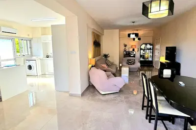 a living room with a person sitting on a couch at Dasoudi Pecora Beach Apartment in Limassol