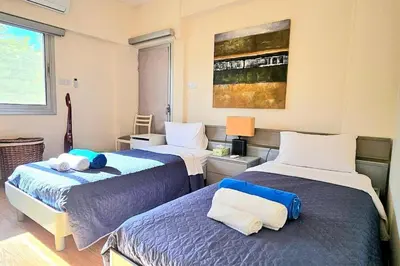 two beds in a room with two beds sidx sidx sidx at Dasoudi Pecora Beach Apartment in Limassol