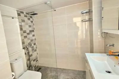 a bathroom with a shower and a toilet and a sink at Dasoudi Pecora Beach Apartment in Limassol