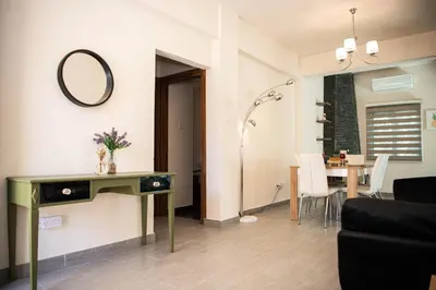 a living room with a table and a mirror on the wall at Bluewave Apartment in Pyla