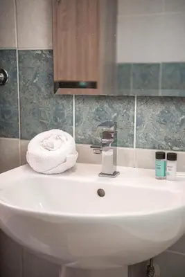 a bathroom sink with a towel and a mirror at Bluewave Apartment in Pyla