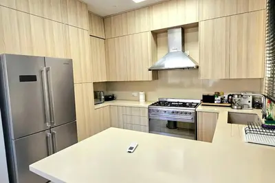 a kitchen with wooden cabinets and a stainless steel refrigerator at Pareklisia Mystical Haven in Parekklisha