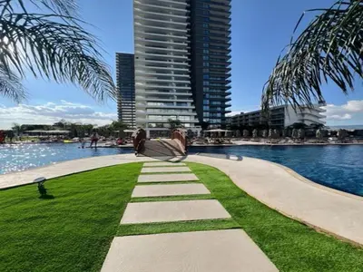 a walkway next to a body of water with a tall building at Grand Sapphire,Luxury Residence BY Report Homes Northern Cyprus in Ayia Napa