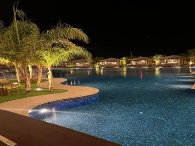 a swimming pool at night with palm trees and houses at Grand Sapphire,Luxury Residence BY Report Homes Northern Cyprus in Ayia Napa