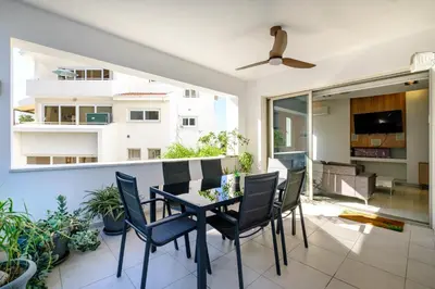 a dining room with a table and chairs on a balcony at Parkside 2 Bedroom Apartment in Larnaka