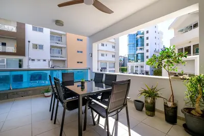a dining room with a table and chairs on a balcony at Parkside 2 Bedroom Apartment in Larnaka