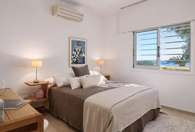 a bedroom with a bed and a window at Melon Boutique Seafront Apartment in Limassol
