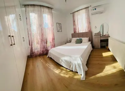 a bedroom with a white bed and a wooden floor at 3 bedroom villa in Voroklini