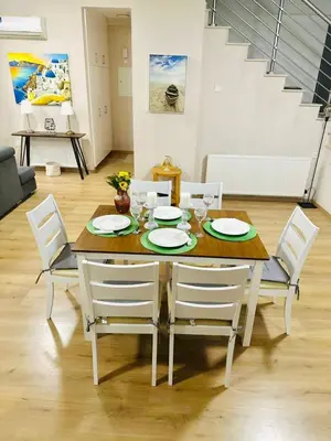 a dining room table with white chairs and a table and a table and chairsktop at 3 bedroom villa in Voroklini