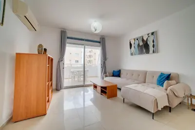 a living room with a couch and a table at Cozy Mackenzie Getaway in Larnaka