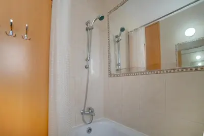 a bathroom with a shower and a tub and a mirror at Cozy Mackenzie Getaway in Larnaka