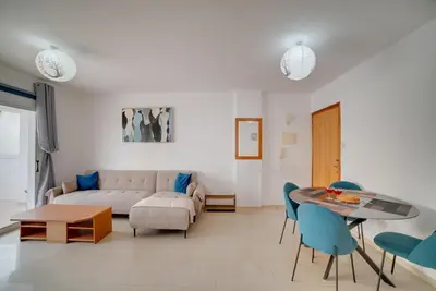 a living room with a couch and a table and chairs at Cozy Mackenzie Getaway in Larnaka