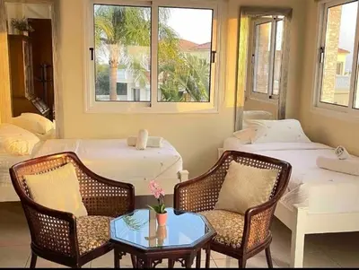 a room with two beds and a table and chairs at Villa Flamingo ,private pool & Sea view in Ayia Napa