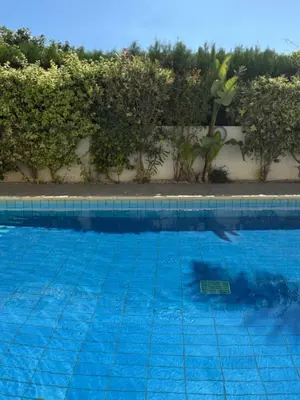 a blue swimming pool with a reflection in the water at NEW - Agia Marina - Rural Retreat with Shared Pool & Parking in Avgorou