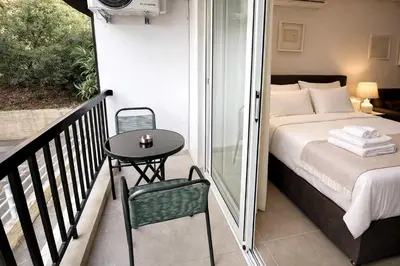 a bedroom with a bed and a table on a balcony at White Arches Studio Suite by TrulyCyprus in Limassol