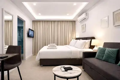 a hotel room with a bed and a couch at White Arches Studio Suite by TrulyCyprus in Limassol