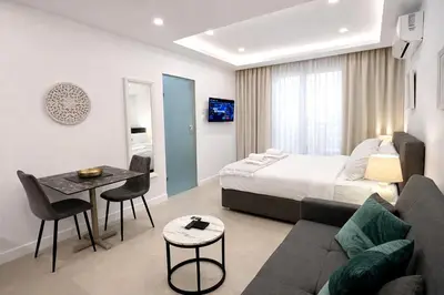 a hotel room with a bed and a couch at White Arches Studio Suite by TrulyCyprus in Limassol