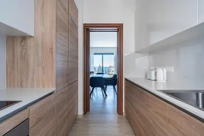 a kitchen with white counters and a table with a view at Pearl Beach Luxury Family Suite in Limassol