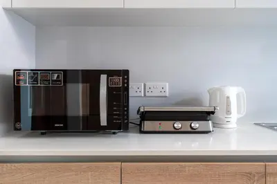 a microwave and a toaster oven on a kitchen counter at Pearl Beach Luxury Family Suite in Limassol