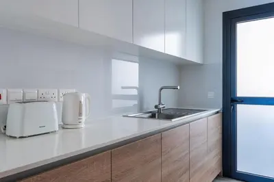 a white kitchen with a sink and a counter at Pearl Beach Luxury Family Suite in Limassol