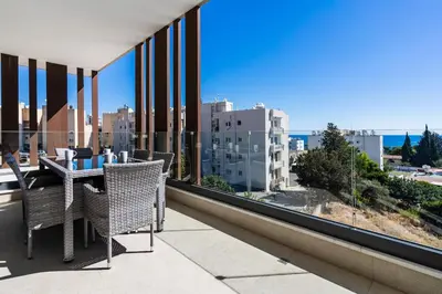 a balcony with a table and chairs and a view of the city at Pearl Beach Luxury Family Suite in Limassol