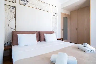 a bedroom with a large white bed with two towels on it at Beachfront Luxury Living Limassol in Limassol