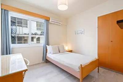 a small bedroom with a bed and a window at Spacious City Centre Living in Nicosia