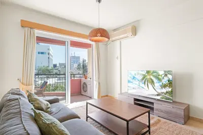 a living room with a couch and a table and a tv at Spacious City Centre Living in Nicosia