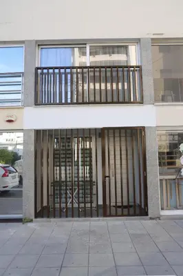 a building with a gate and a parking lot at ELIA Elegant Central Suite Larnaca in Larnaka