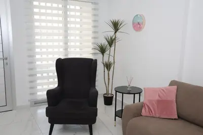 a living room with a chair and a couch at ELIA Elegant Central Suite Larnaca in Larnaka