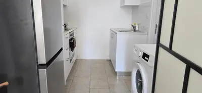 a white kitchen with a washer and dryer in it at Habito Luxury Apartment - Breakbooking CY in Limassol