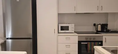 a kitchen with a stainless steel refrigerator and white cabinets at Habito Luxury Apartment - Breakbooking CY in Limassol