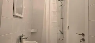 a white bathroom with a shower and a sink at Habito Luxury Apartment - Breakbooking CY in Limassol