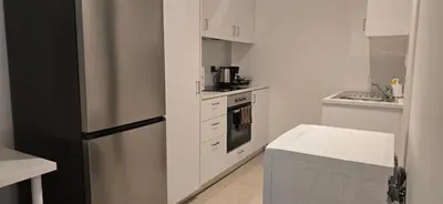 a white kitchen with a refrigerator and a stove at Habito Luxury Apartment - Breakbooking CY in Limassol