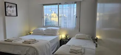 two beds in a white room with a window at Executive 2BR Spacious Apartment , Limassol Center, 2 Balconies, Ideal Business Stay - SuperCentro! in Limassol