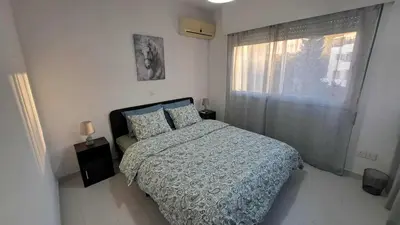 a bedroom with a bed and a window at City center beach and supermarket walking distance in Limassol