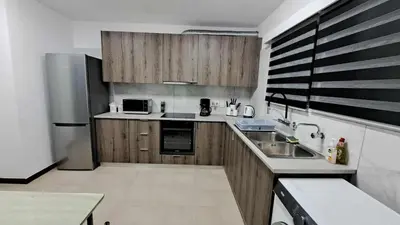 a kitchen with wooden cabinets and a stainless steel refrigerator at City center beach and supermarket walking distance in Limassol
