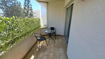 a balcony with two chairs and a table and a window at City center beach and supermarket walking distance in Limassol