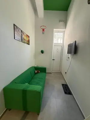 a green couch in a living room with a basketball hoop at GREEN Cabin-Larnaca Centrum in Larnaka