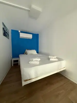 a bedroom with a bed with a blue headboard at BLUE Cabin-Larnaca Centrum in Larnaka