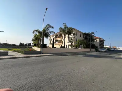 an empty street in front of a house with palm trees at 2 Bedroom Penthouse Apartment With Swimming Pool in Kiti