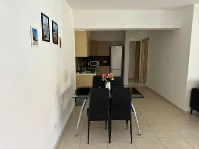 a dining room with a table and chairs and a kitchen at 2 Bedroom Penthouse Apartment With Swimming Pool in Kiti