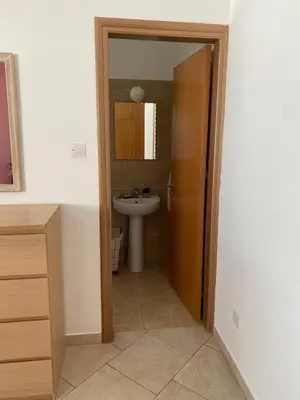 a bathroom with a sink and a toilet and a mirror at Holiday House in Oroklini in Voroklini