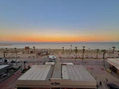 a view of a beach with palm trees and the ocean at Golden Nest by the Sea in Larnaka