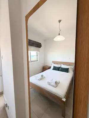 a bedroom with a bed with towels on it at Golden Nest by the Sea in Larnaka