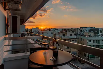 a balcony with a table and two glasses of wine at TelMar Sky View in Larnaka