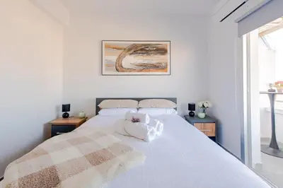 a white bed with a stuffed animal on top of it at TelMar Sky View in Larnaka