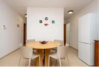 a dining room with a table and a refrigerator at Stella's Little Island Gem in Paralimni