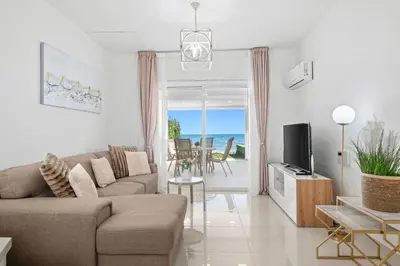a living room with a couch and a tv at Wavestone Beachfront House in Meneou
