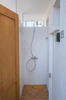 a shower in a white room with a door at Wavestone Beachfront House in Meneou